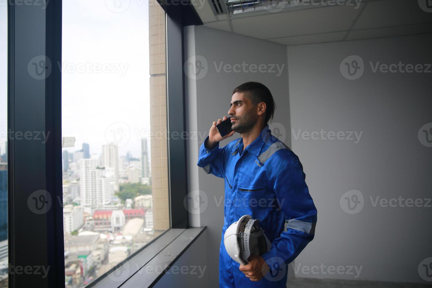 A man in a blue uniform talking on the phone photo