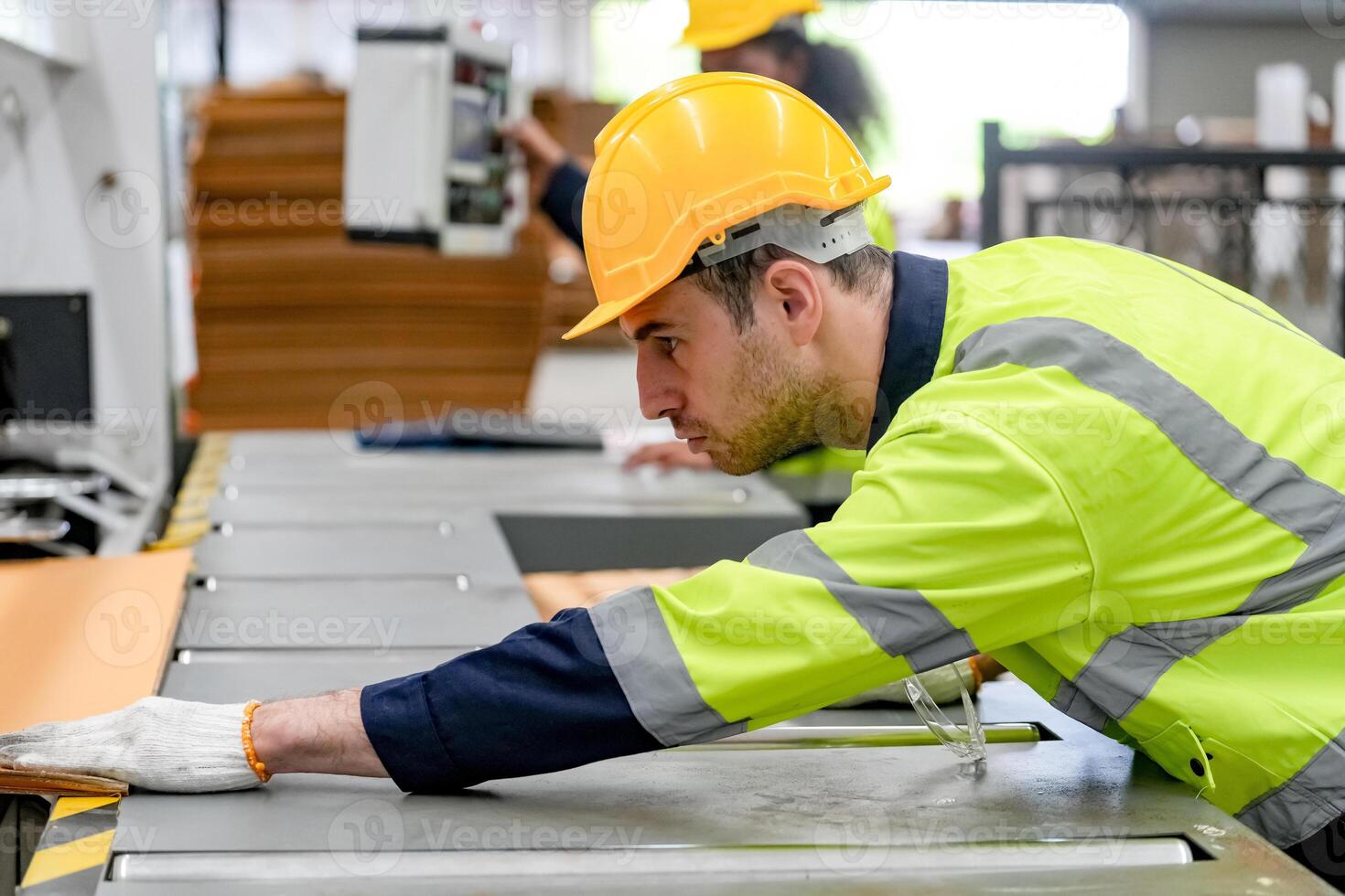 A man in a safety vest working on a machine photo