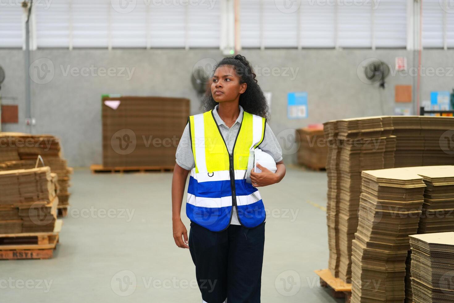A woman in a safety vest walking through a warehouse photo