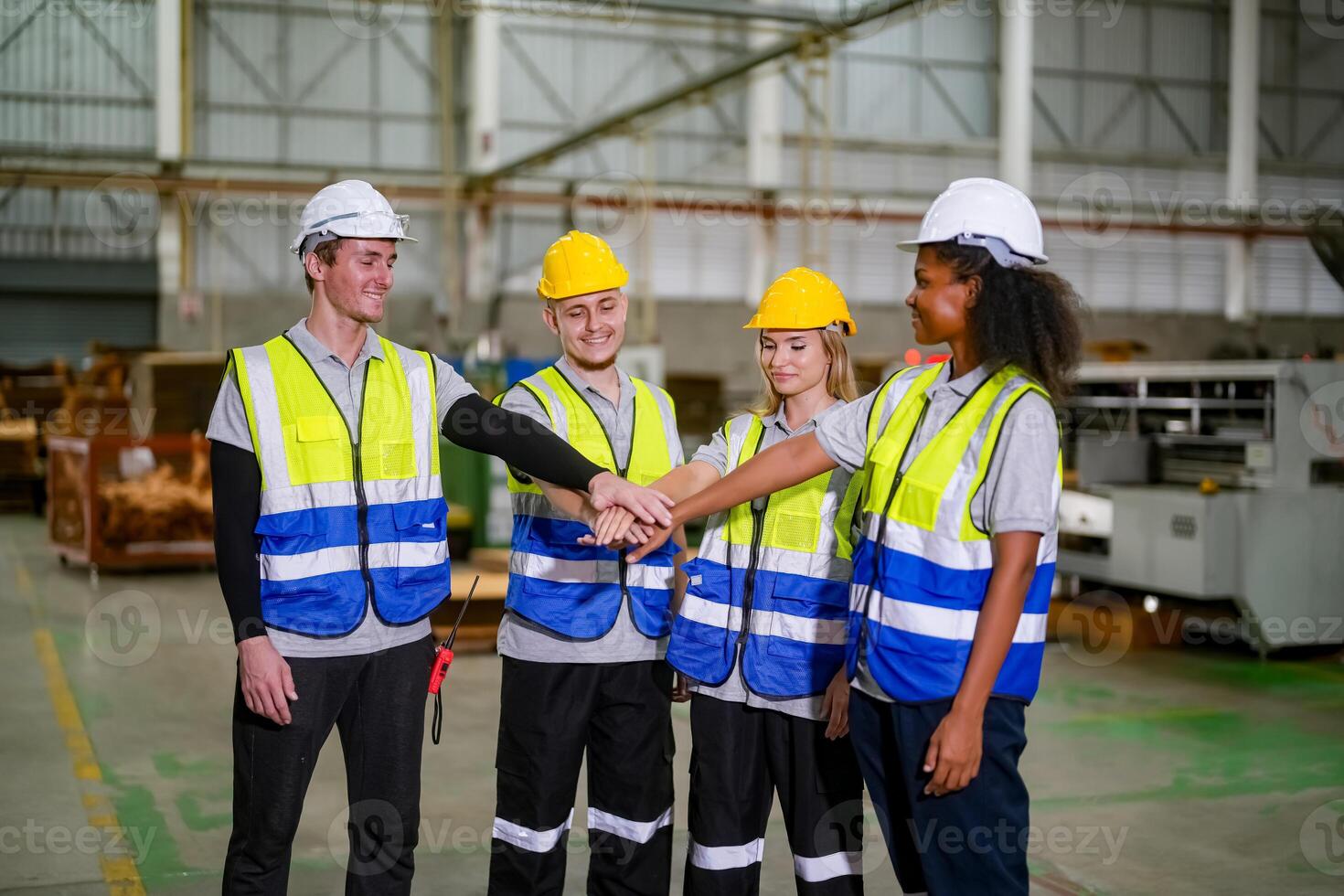 Four people in safety vests shaking hands photo