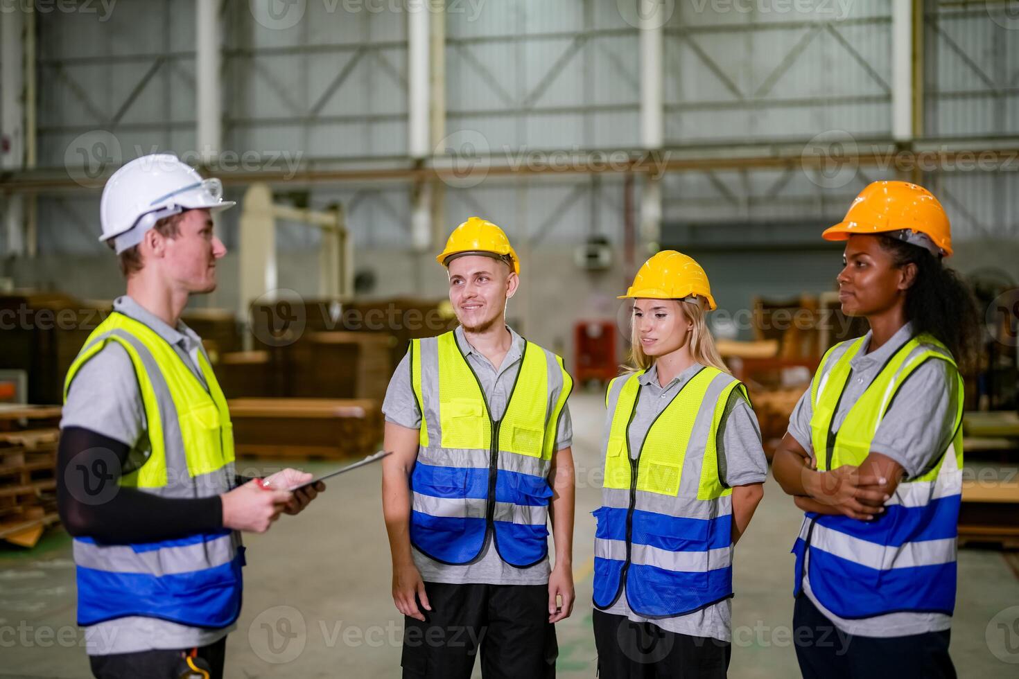 Four people in safety vests talking to each other photo