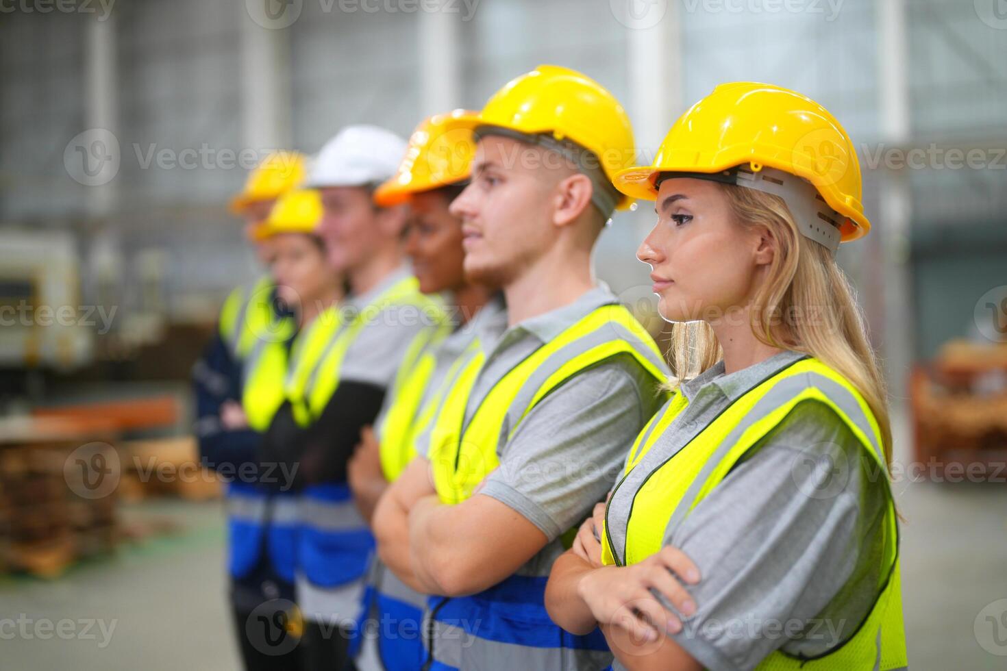 A group of people in hard hats standing in a factory photo