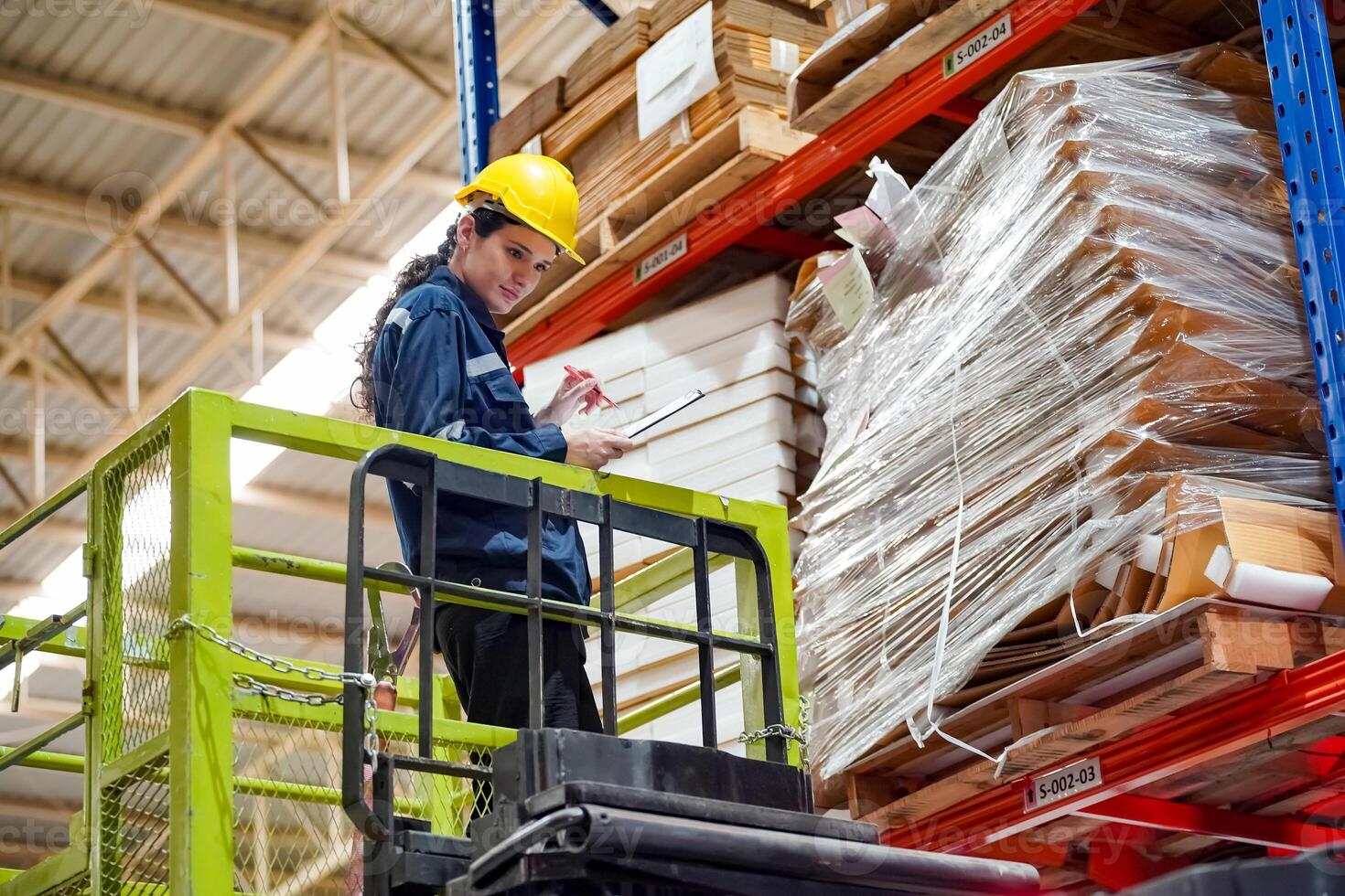 A worker on a forklift in a warehouse photo