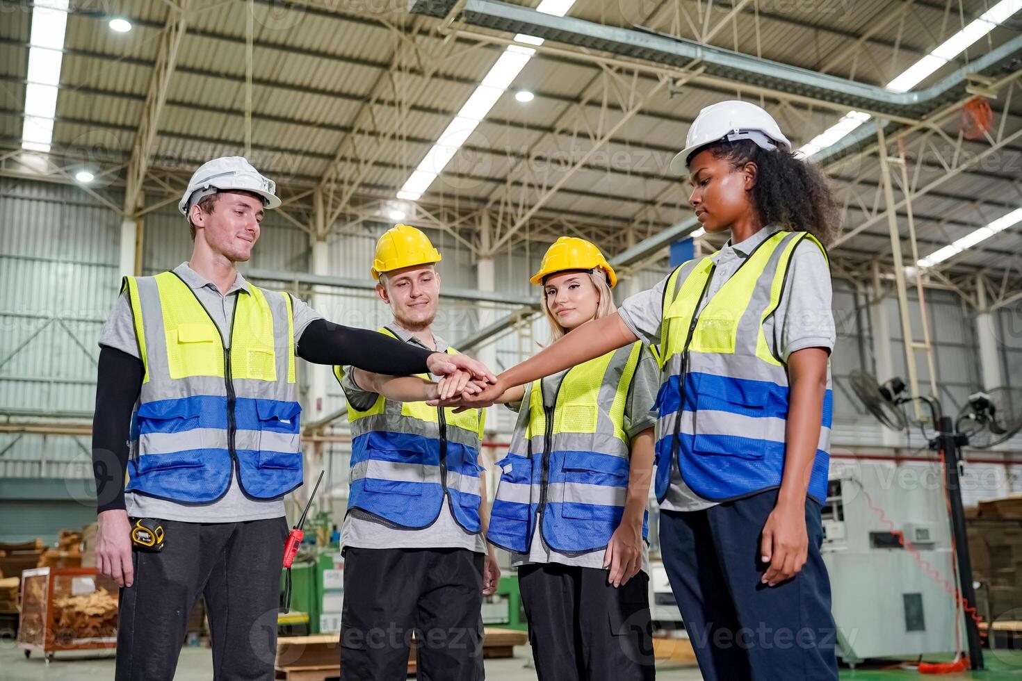Group of workers shaking hands in factory photo