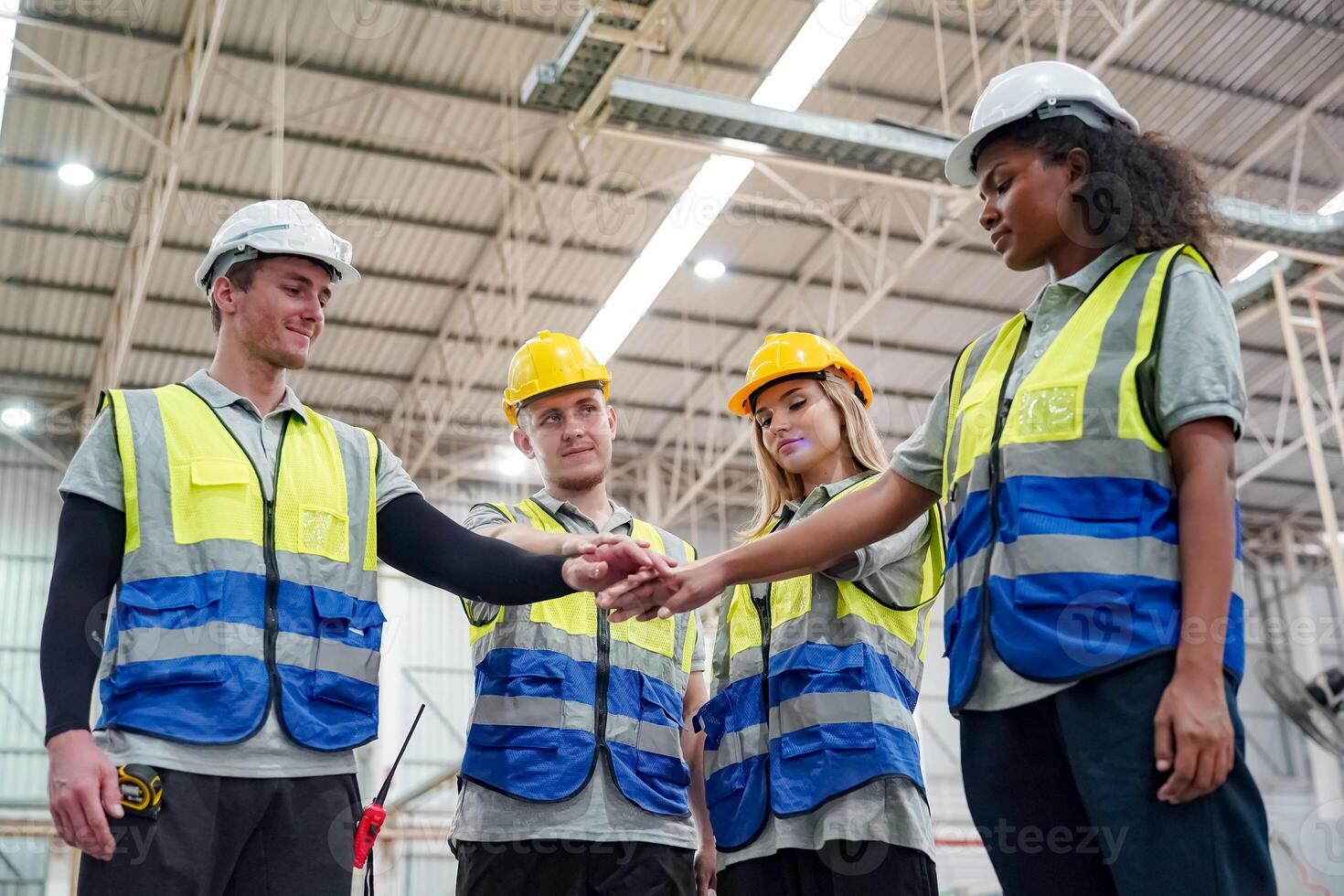 Four people in safety vests shaking hands photo