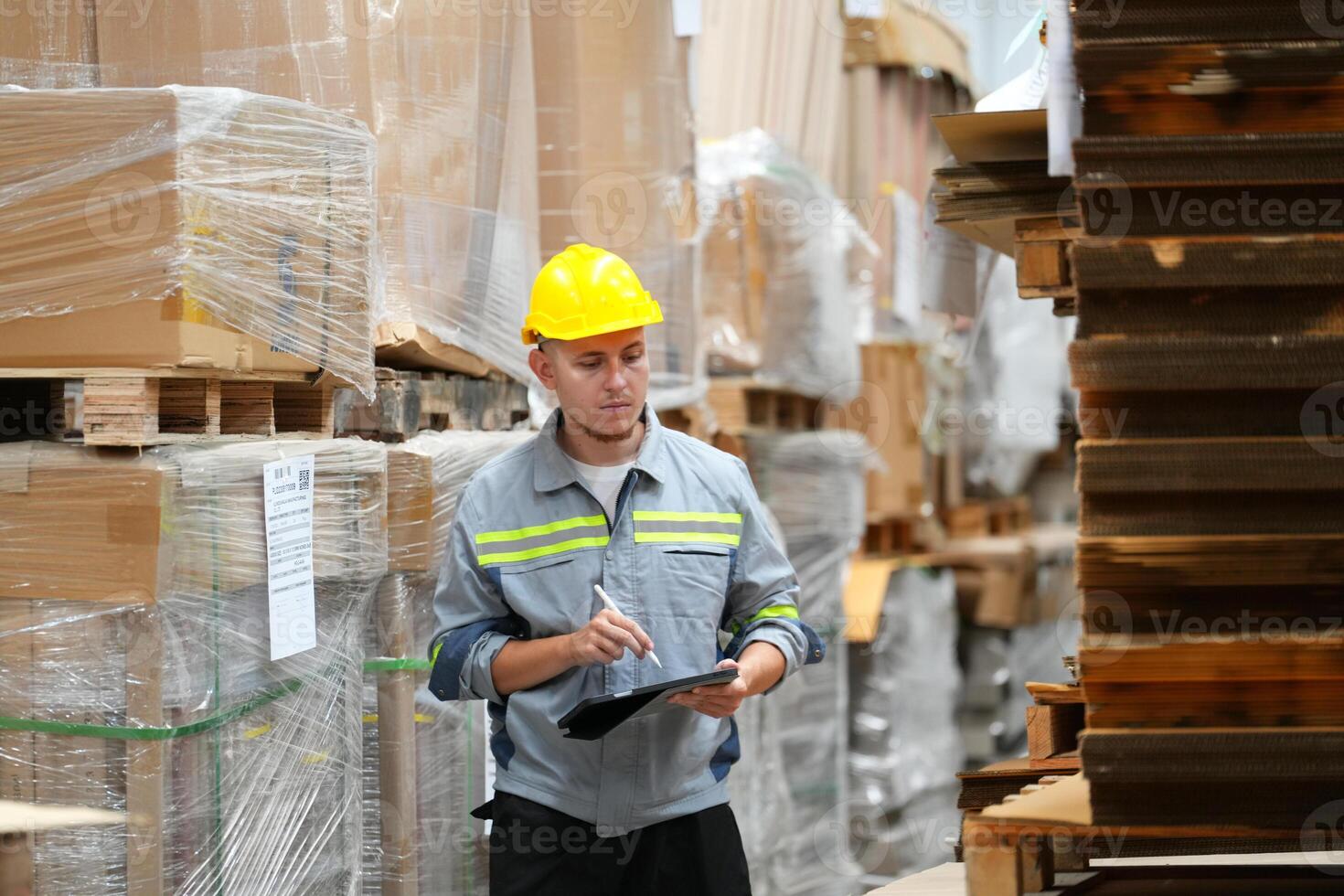 A man in a warehouse with a clipboard photo