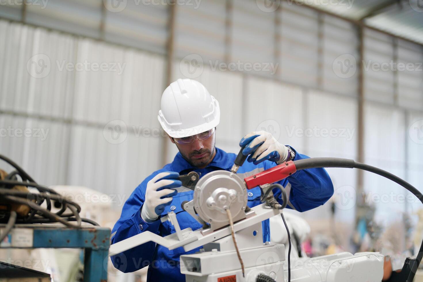 A man in a hard hat working on a machine photo