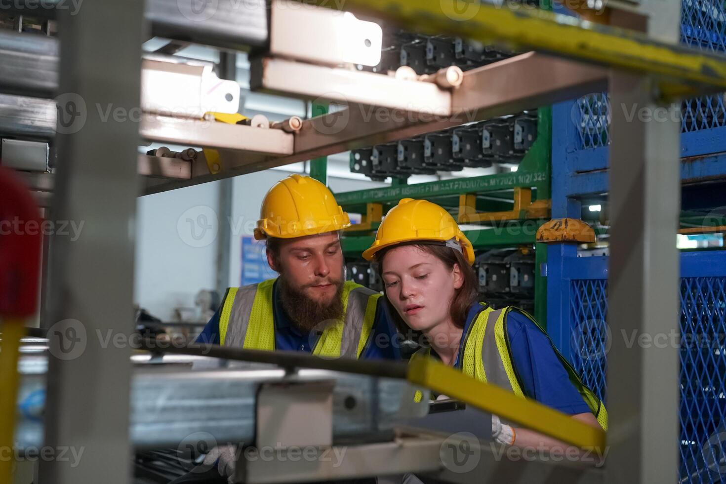 Two people working in a factory with machinery photo