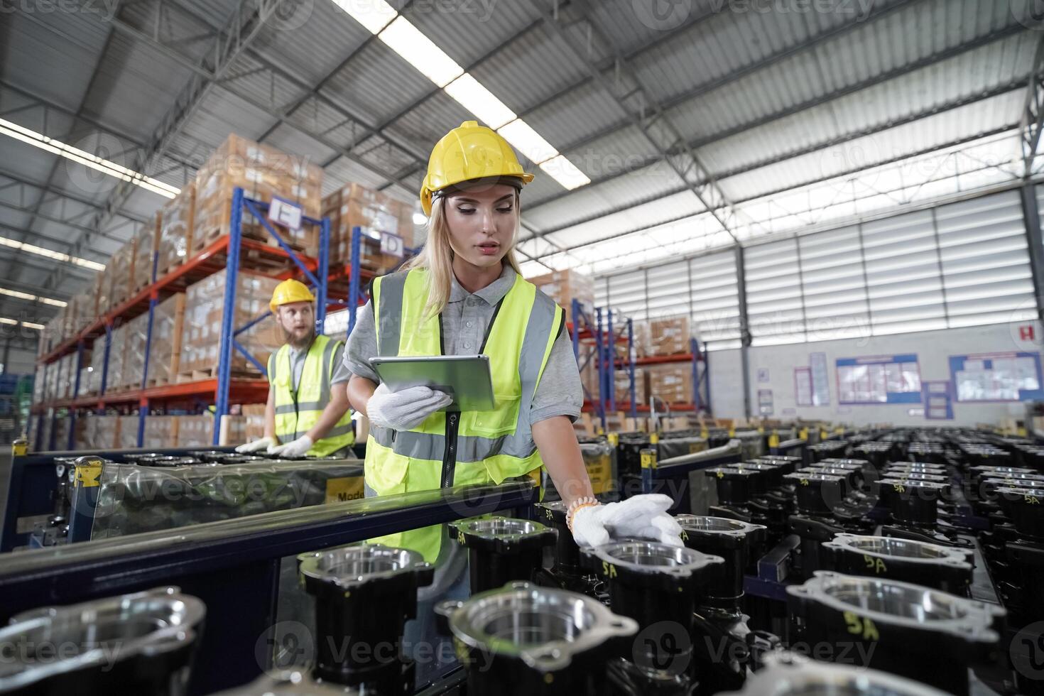 Two workers in a factory looking at a tablet photo