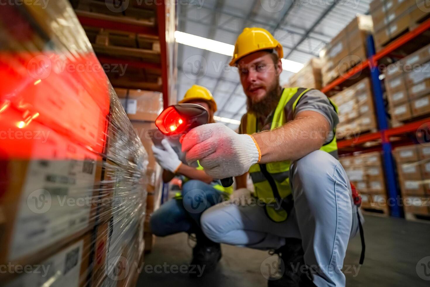 Two workers in safety gear using a laser to check inventory photo