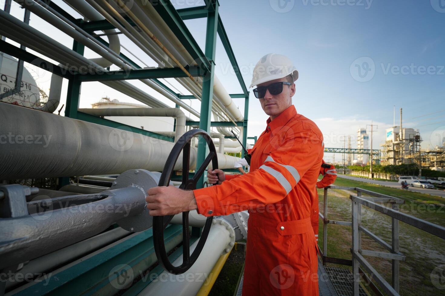 A man in an orange suit and white hat is holding a steering wheel photo