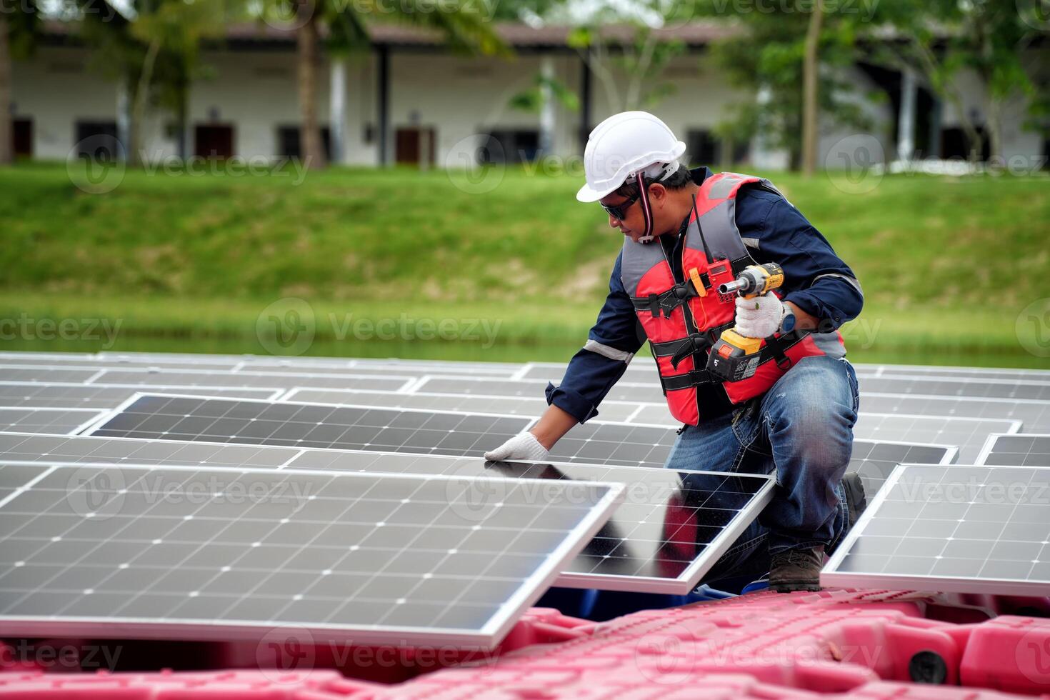 A man in a hard hat and safety vest working on solar panels photo
