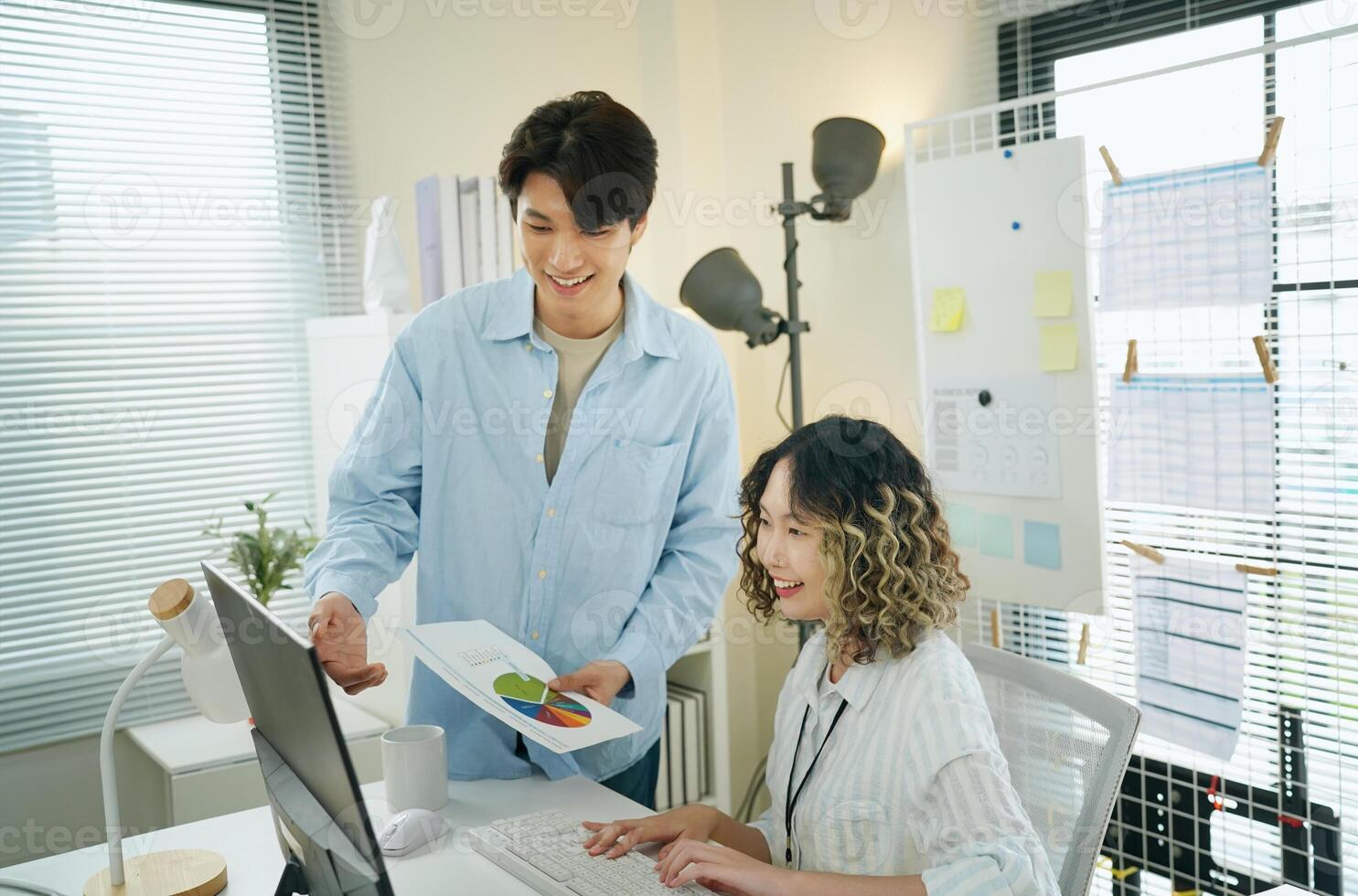Asian couple working on computer in office photo