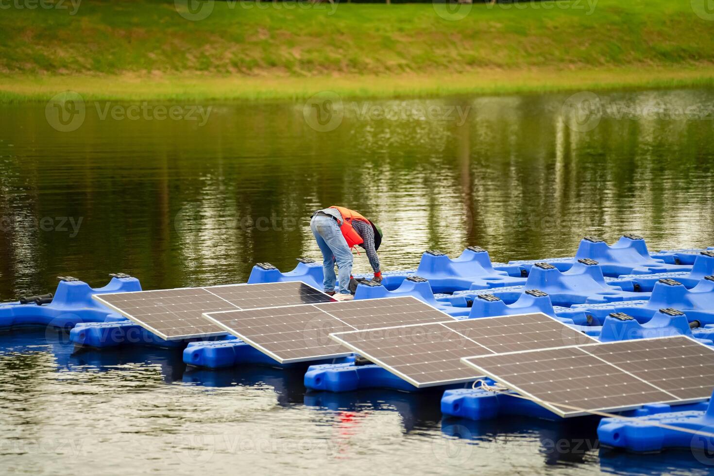 A man is working on a floating solar panel photo