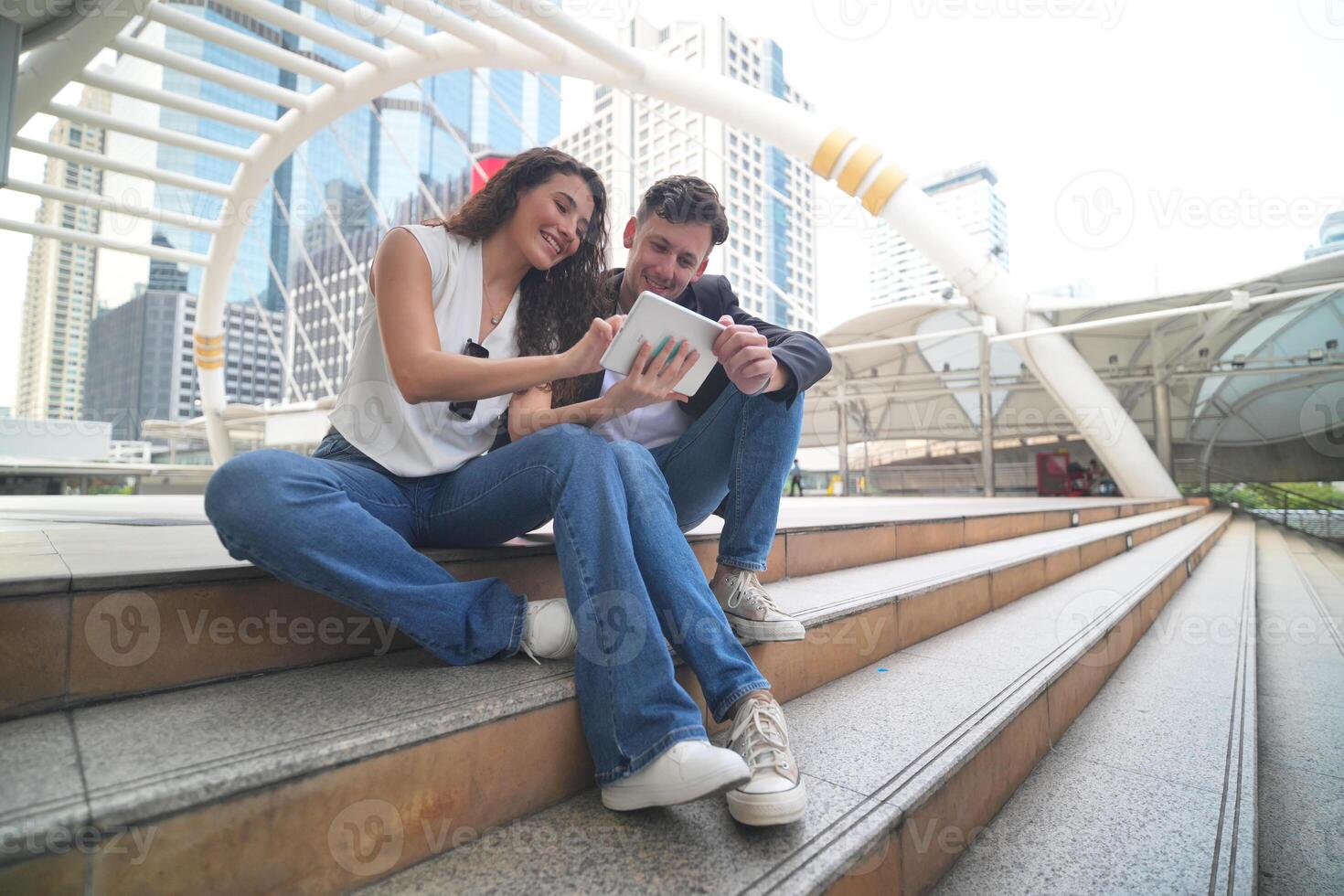 un hombre y mujer sentado en pasos mirando a un tableta foto