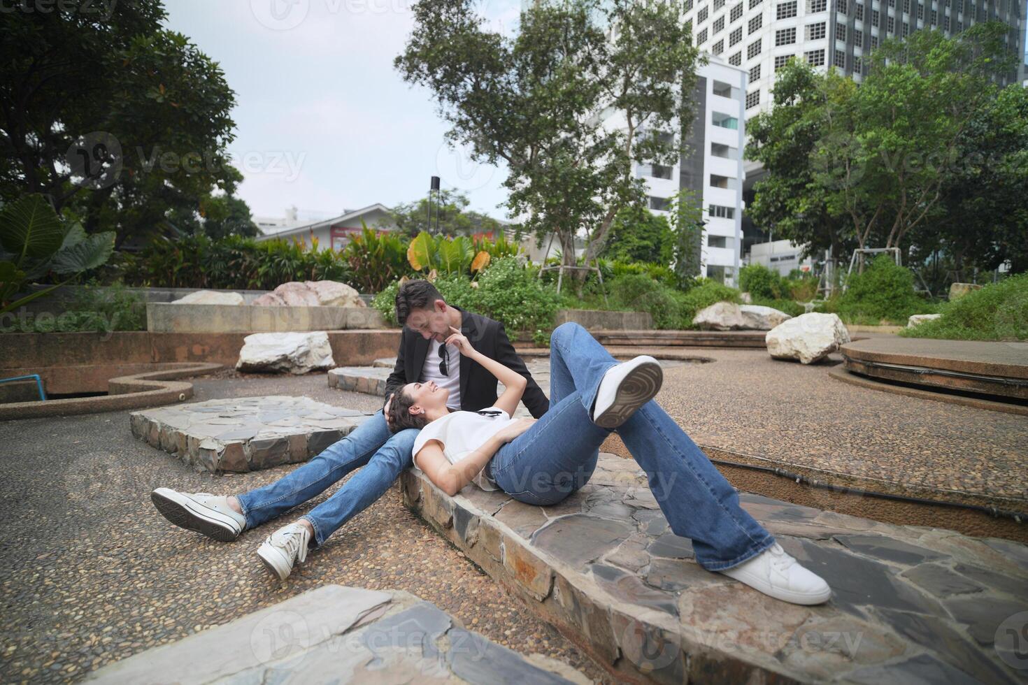 A man and a woman laying on a rock photo