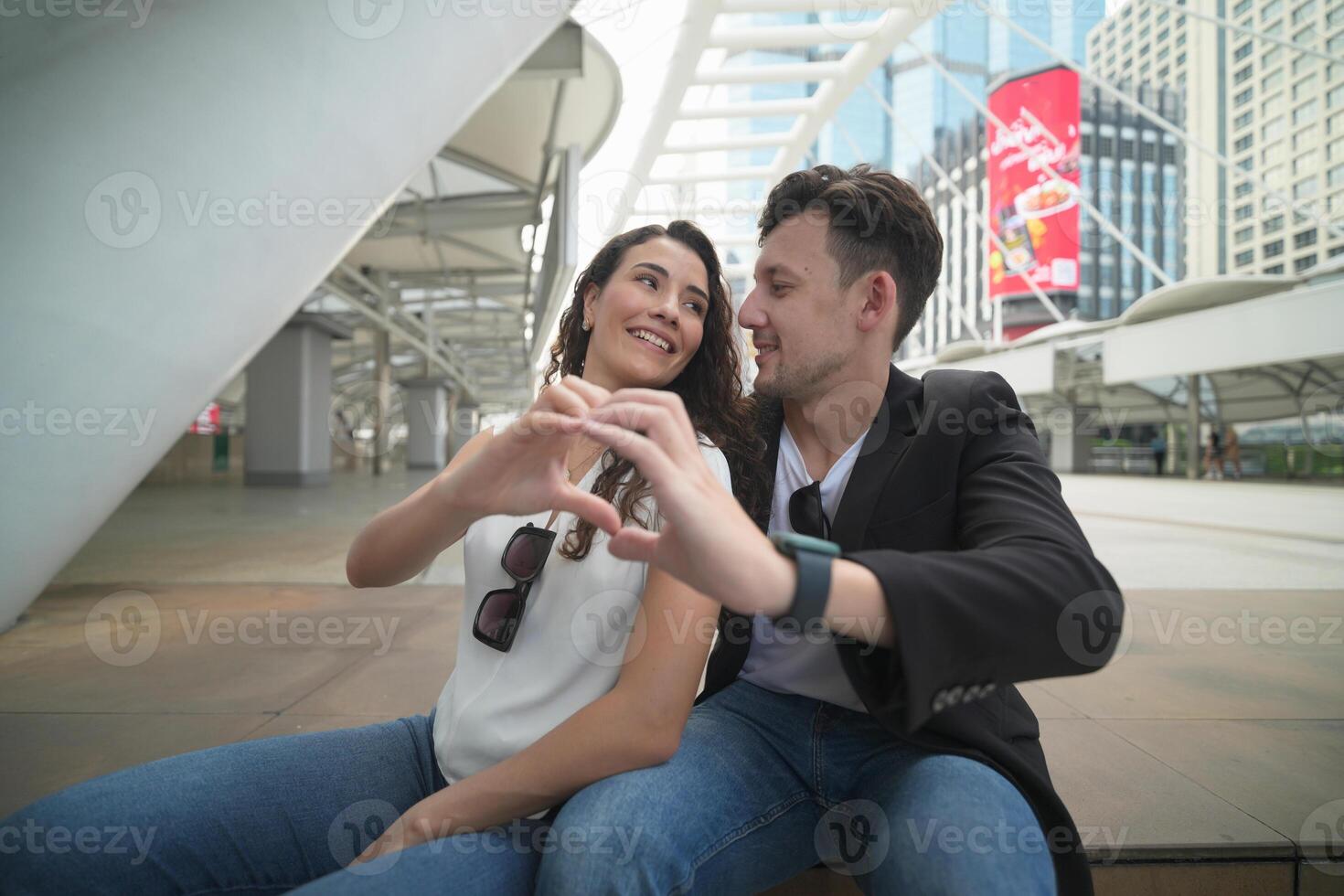 A man and woman are making a heart shape with their hands photo
