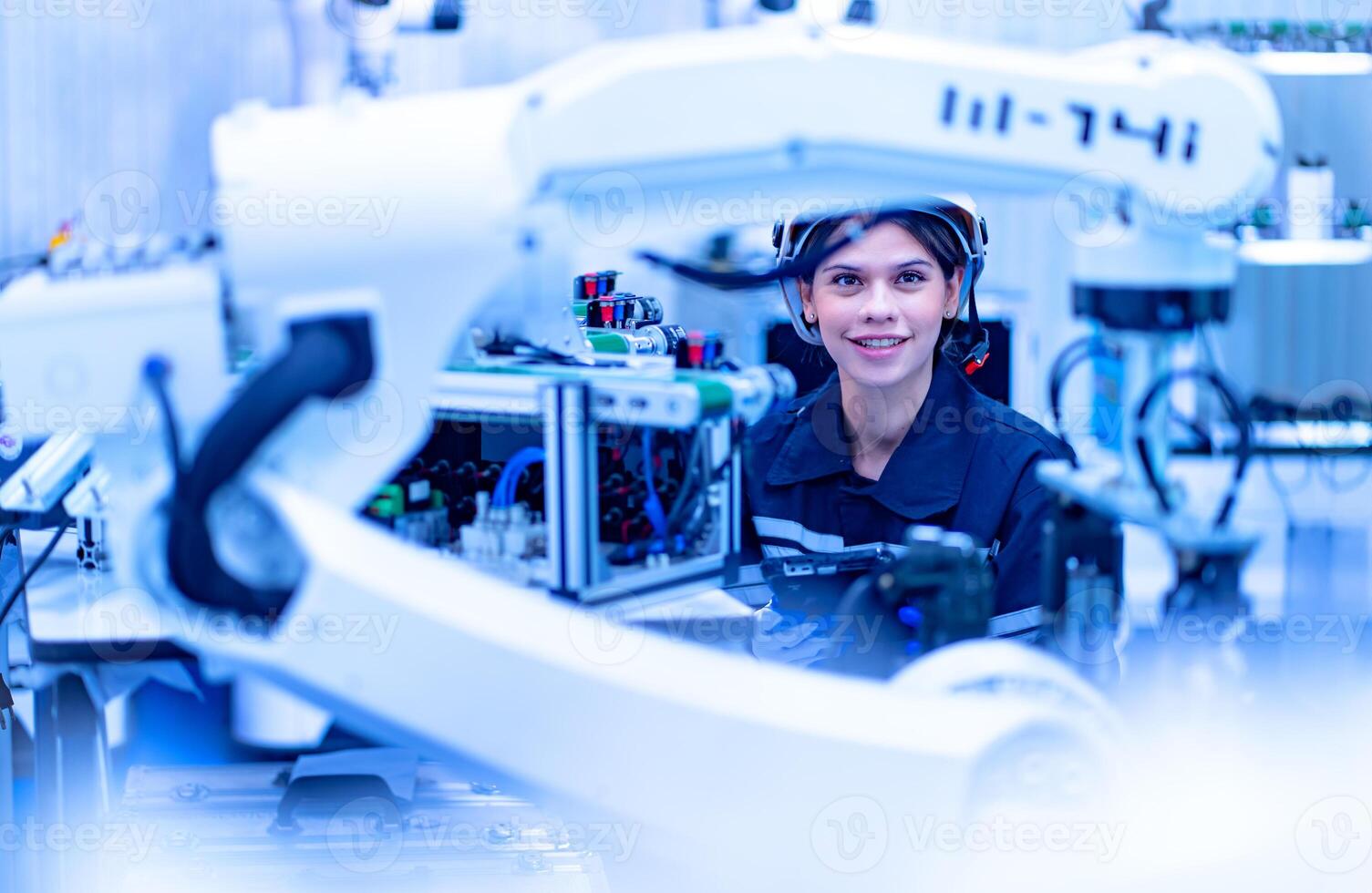 A woman is working on a robot in a factory photo