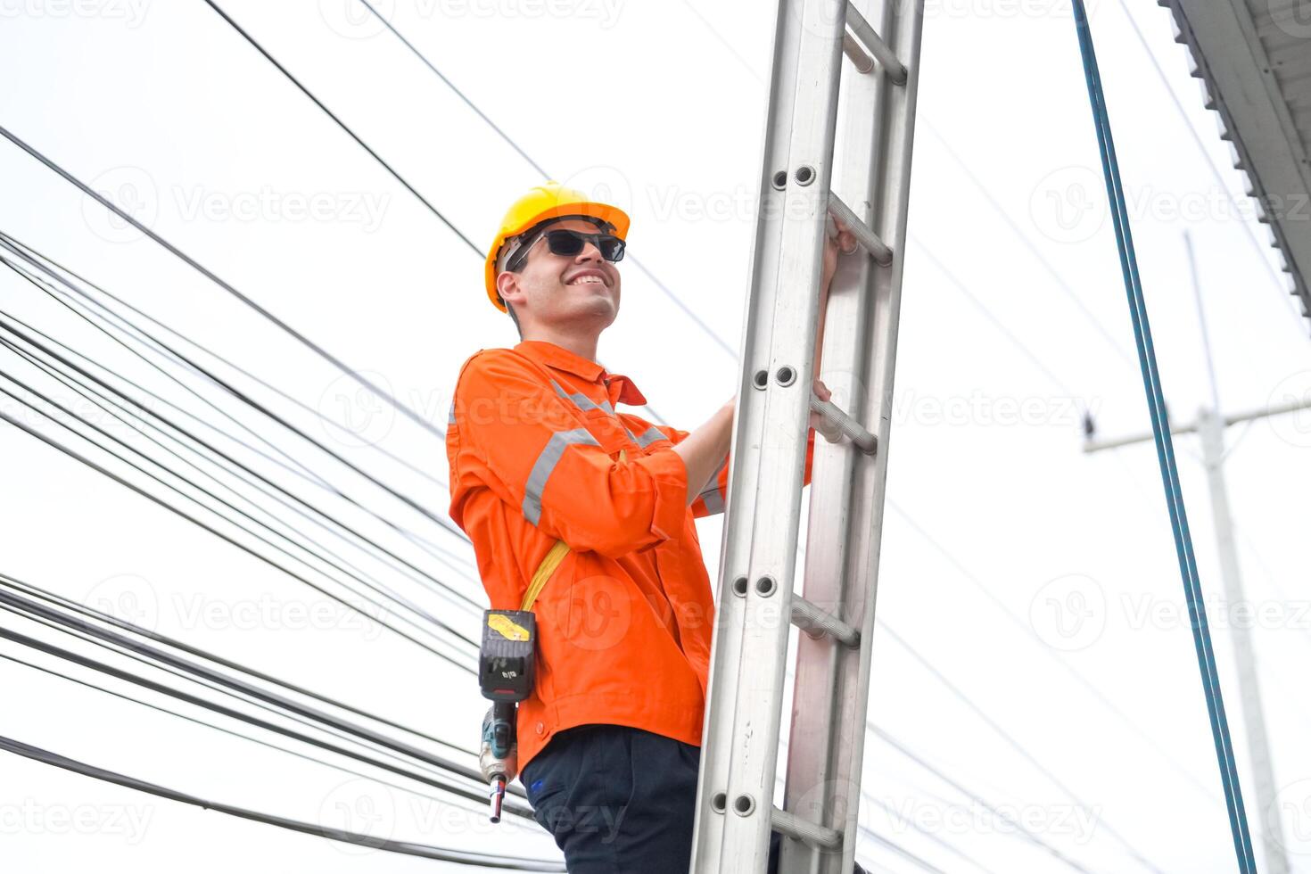 A man in an orange shirt is working on a ladder photo