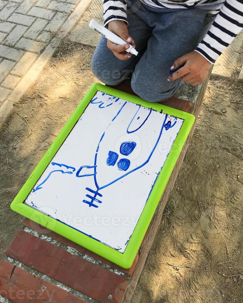 Hands of small student drawing on whiteboards photo