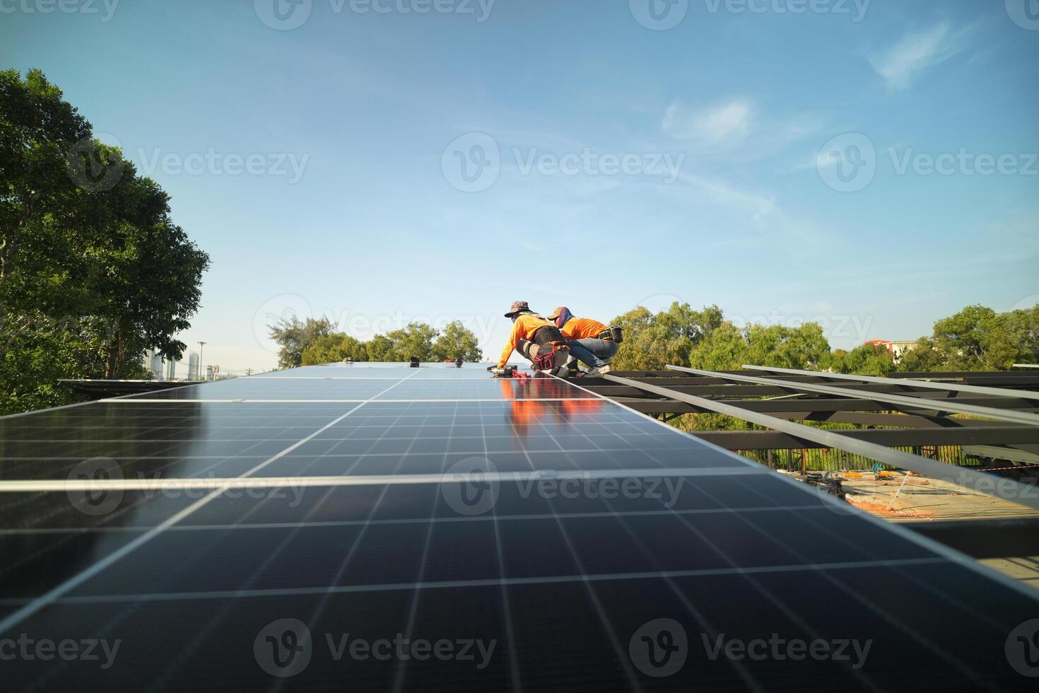 Two men working on a solar panel on a roof photo
