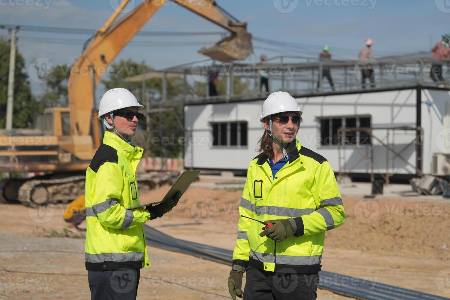 Two surveyor of construction engineer, architect, in hardhat working on construction site. photo