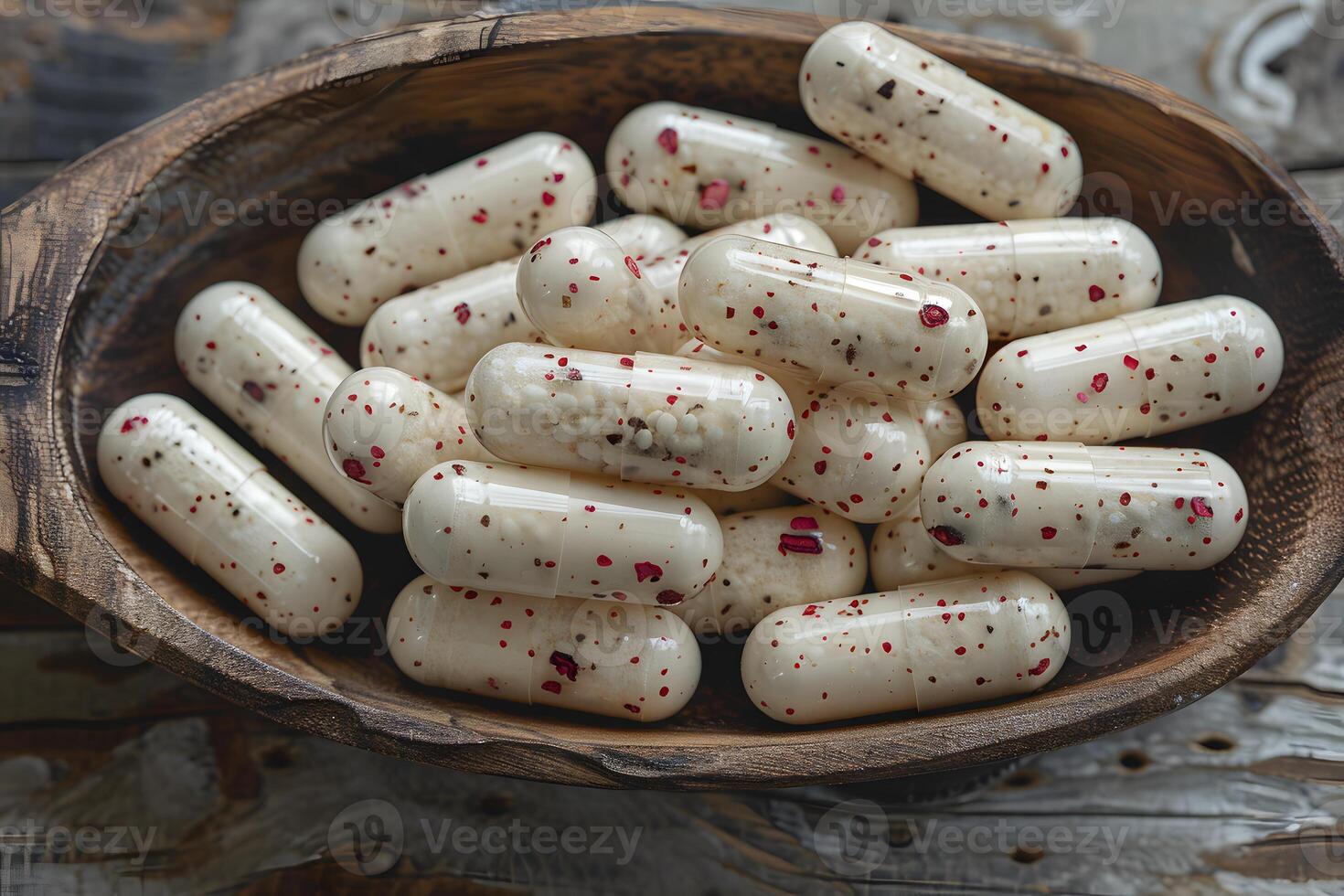 Herbal Medicine Capsules with Red and Black Specks in Wooden Bowl for Alternative Health Concepts photo