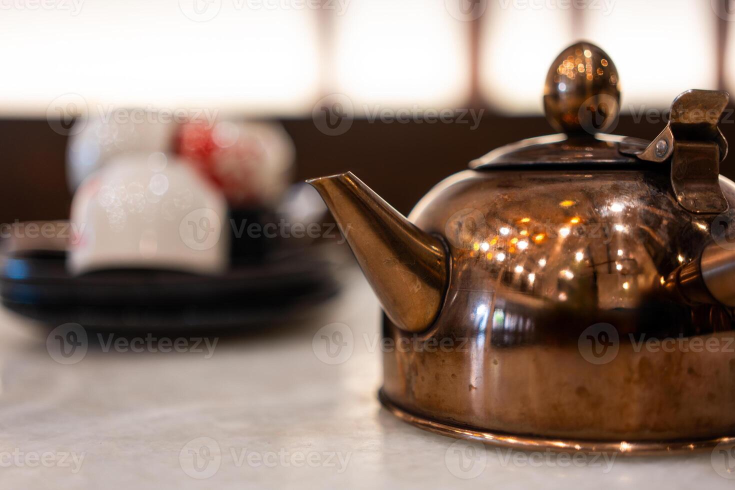 Copper tea pot on table photo