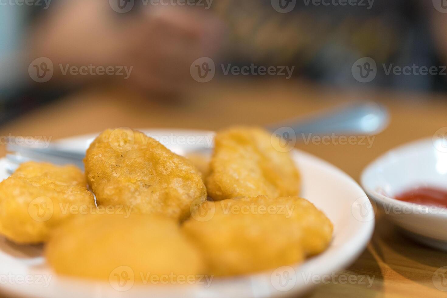 Pile of golden deep fried battered chicken nuggets photo