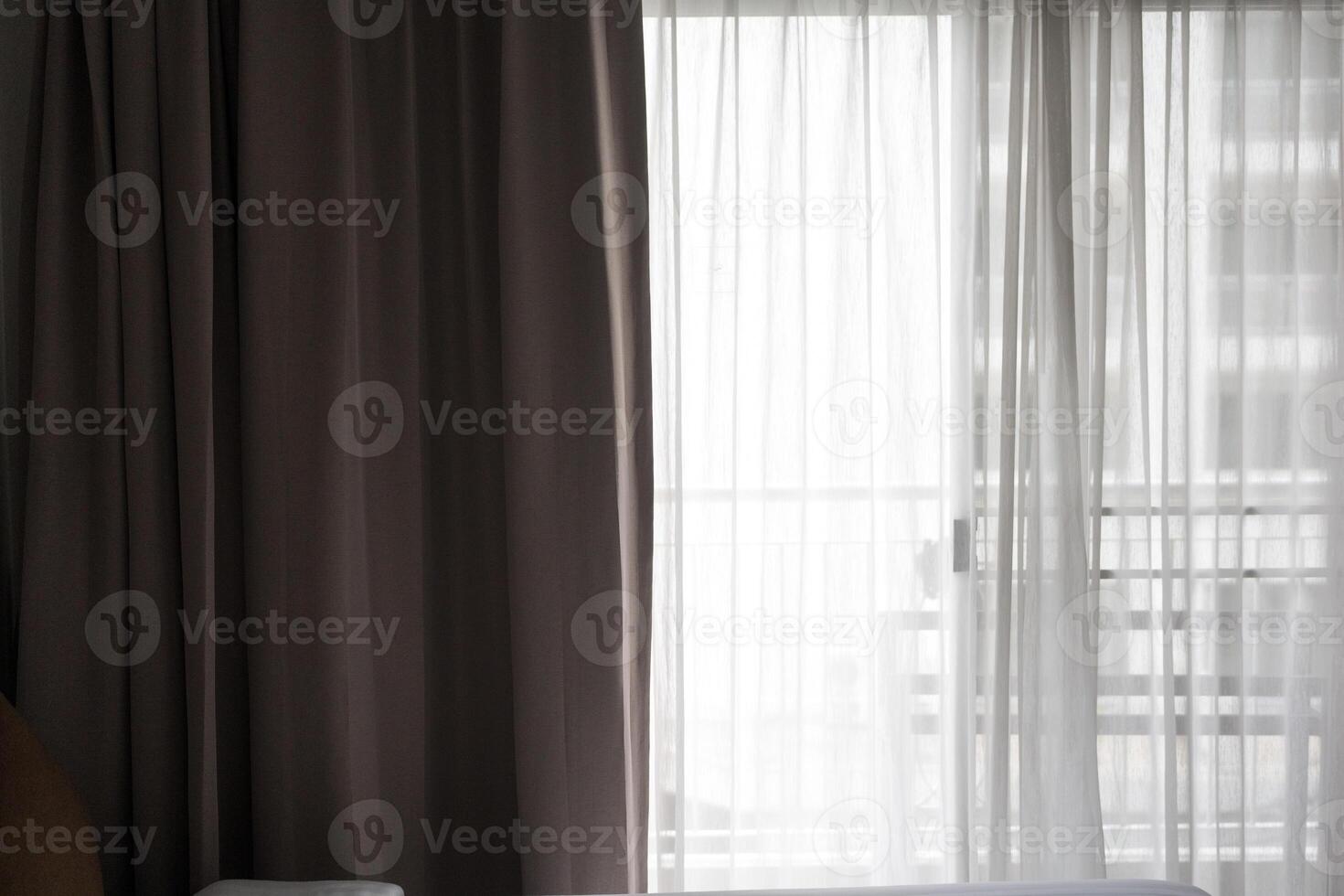 A soft gray curtains sunlit window with sheer curtains. photo