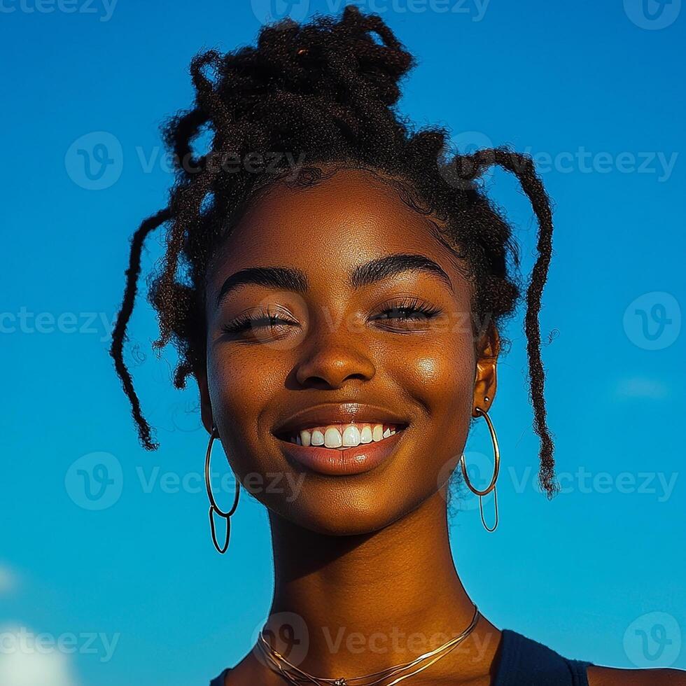 A young woman with dreadlocks smiles at the camera photo