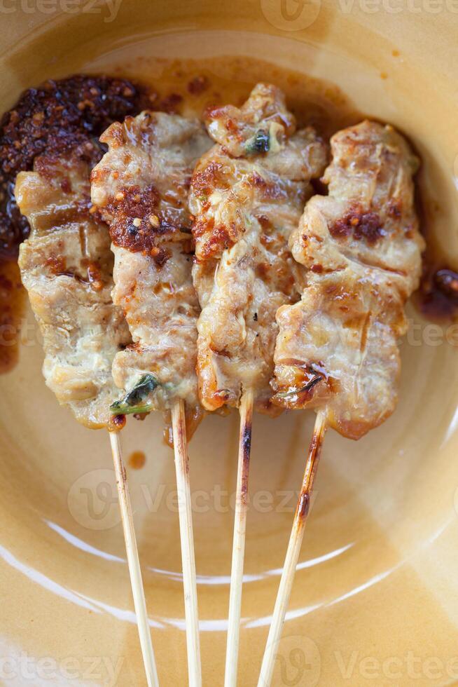 A plate with four skewers of meat on it photo