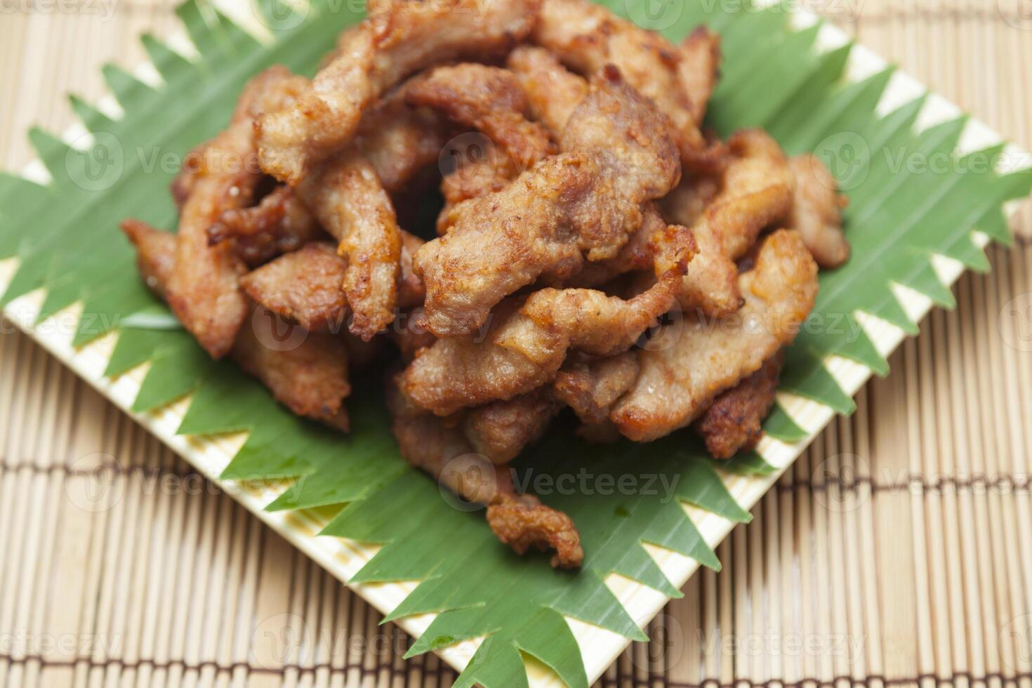 Chicken strips on a bamboo plate on a table photo