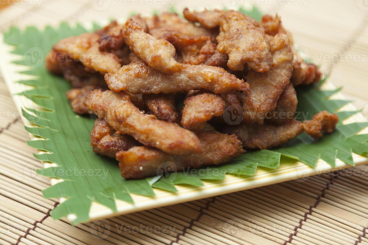 A plate of fried chicken on a bamboo mat photo