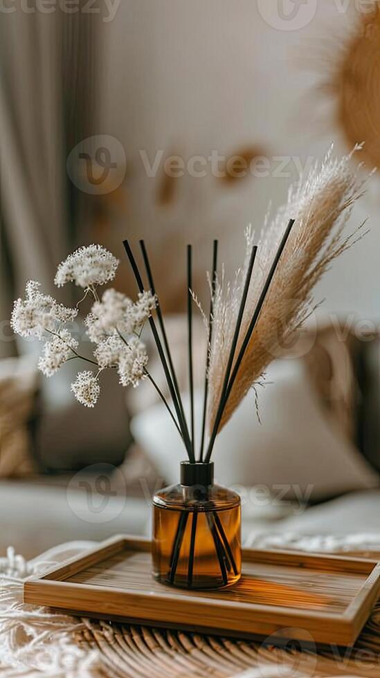 Reed diffuser in a brown glass vase on a wooden tray photo