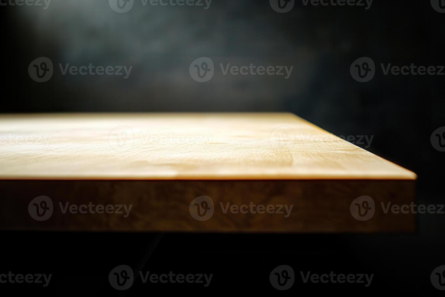 Close-up of a wooden table edge with a dark background. photo