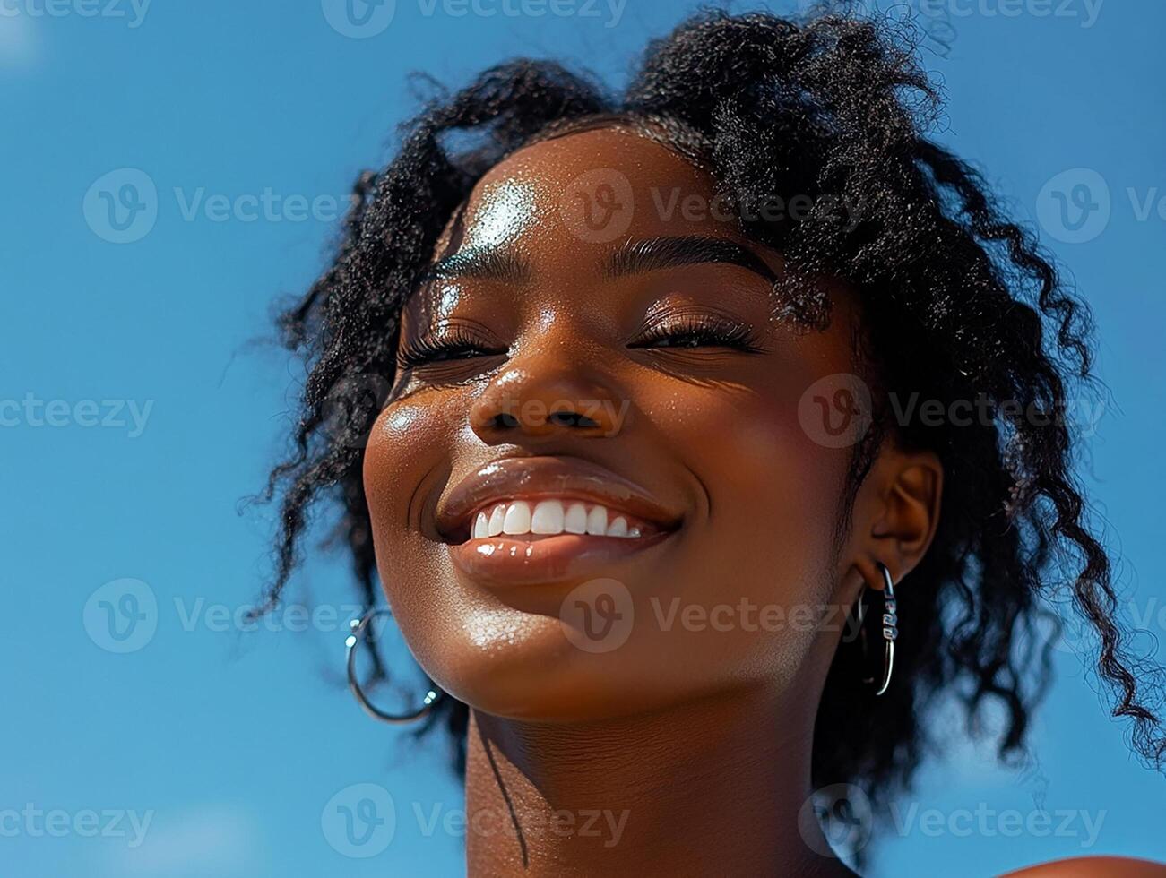 A woman with curly hair smiling and looking up photo