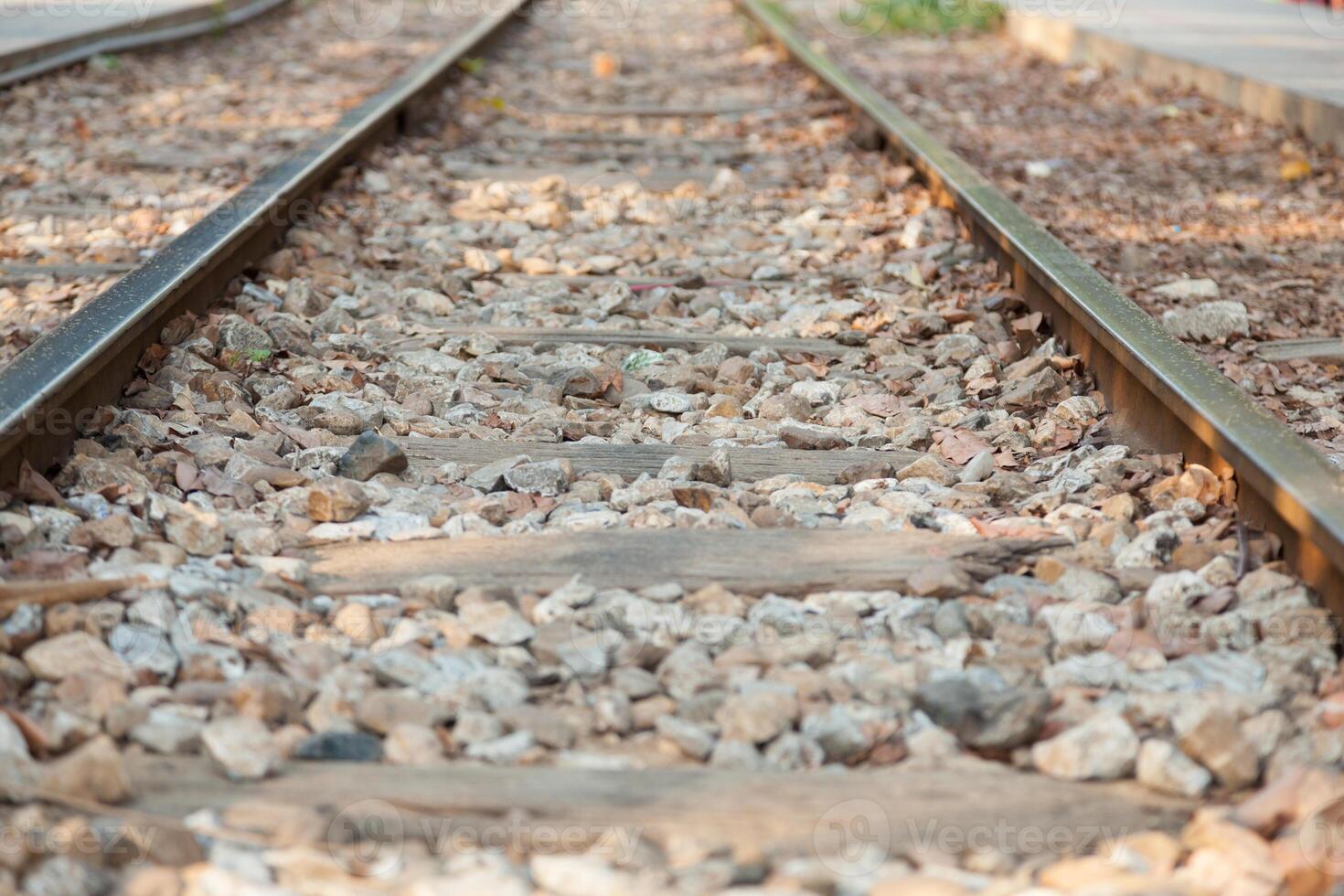A close up of a railroad track with gravel photo
