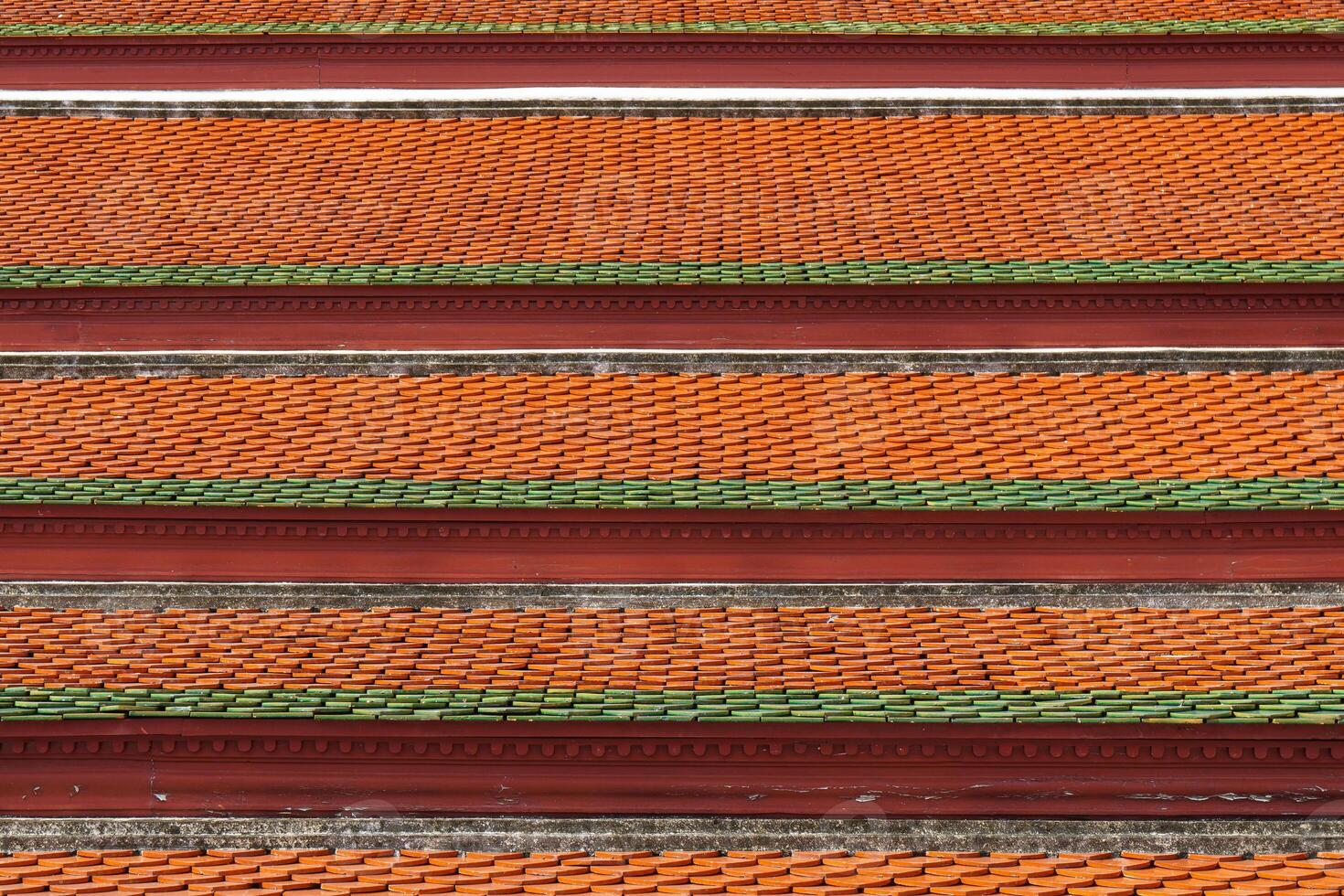 Vibrant orange and green tiles create striking pattern on roof photo