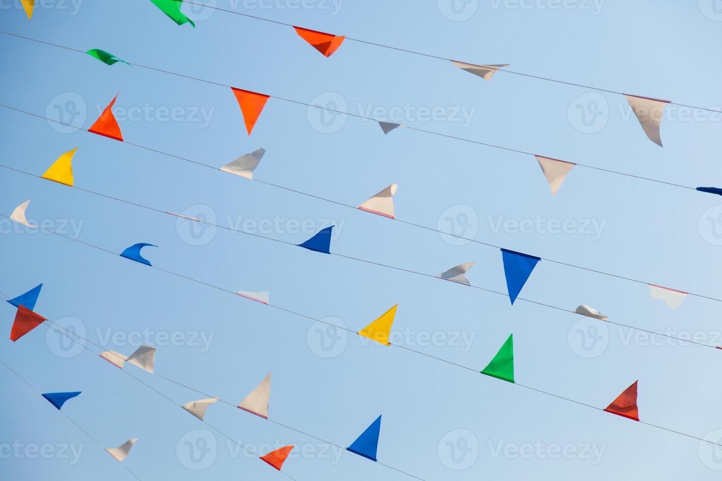 A bunch of colorful paper flags are hanging in the air photo