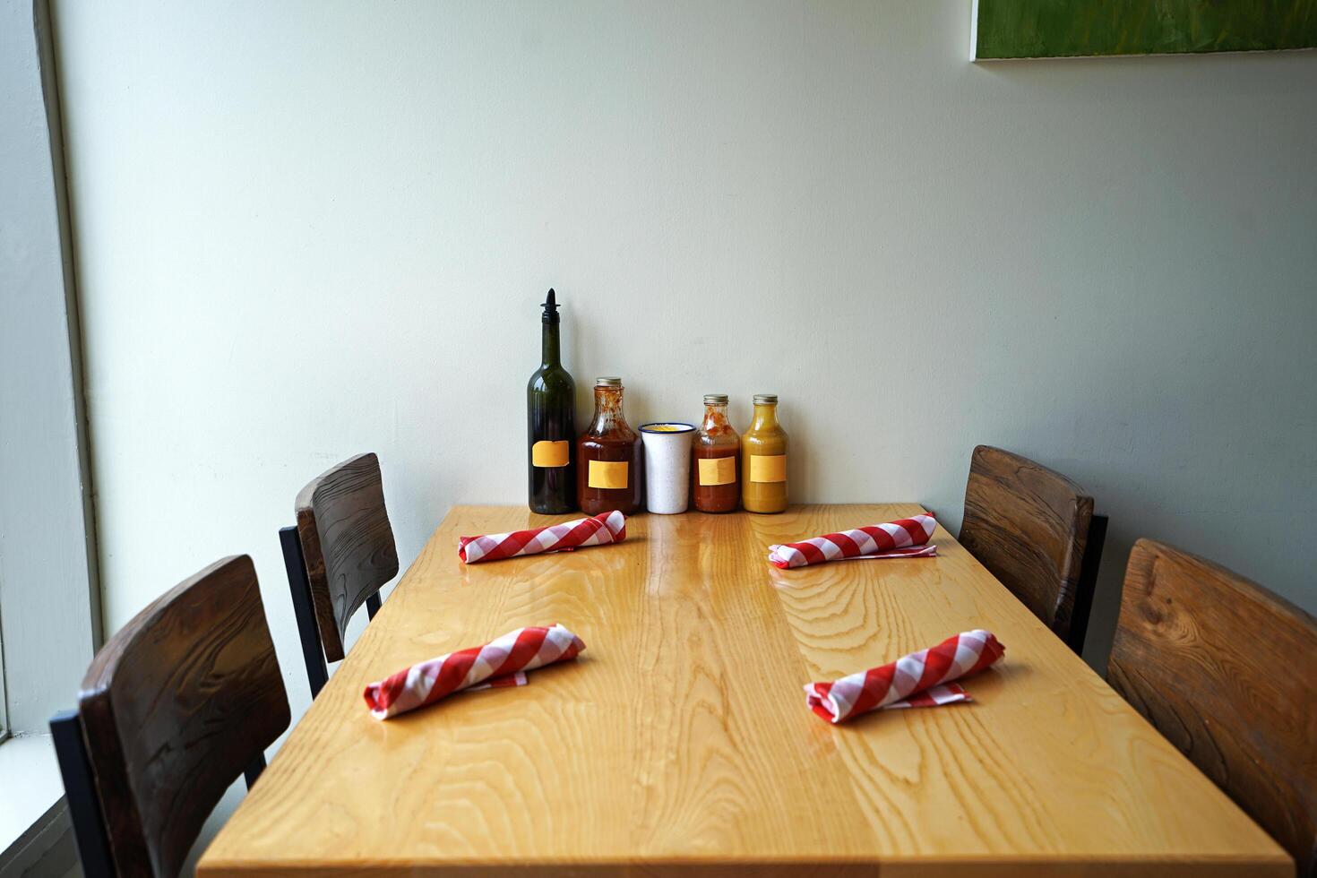 Restaurant table setting and arrangement decorated with dipping sauce bottles and wooden furniture photo