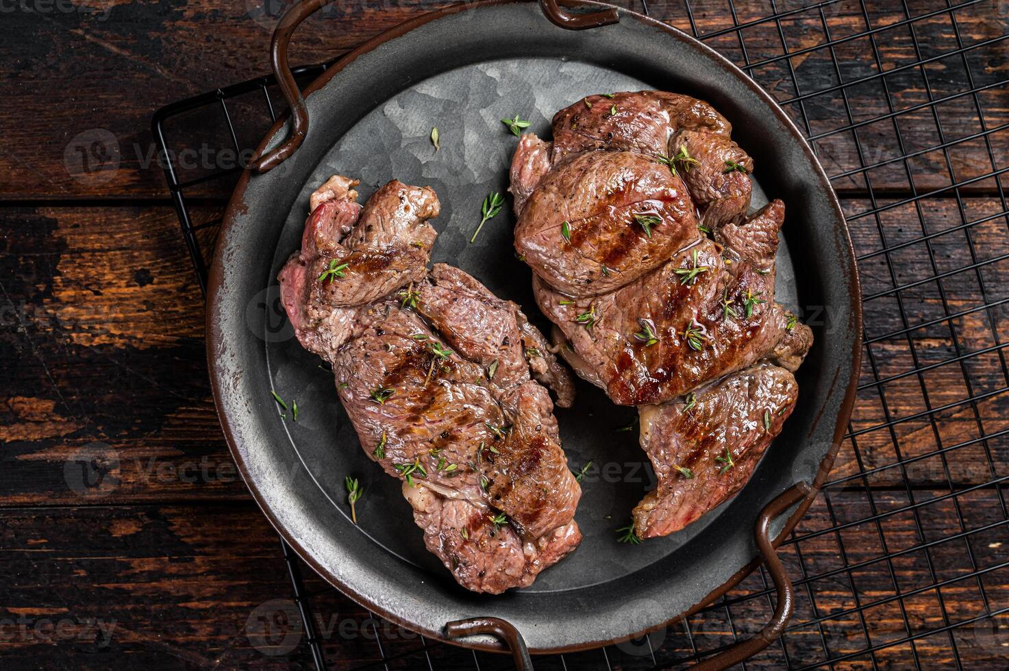 Grilled Lamb chop leg steaks, mutton meat with herbs. Wooden background. Top view photo