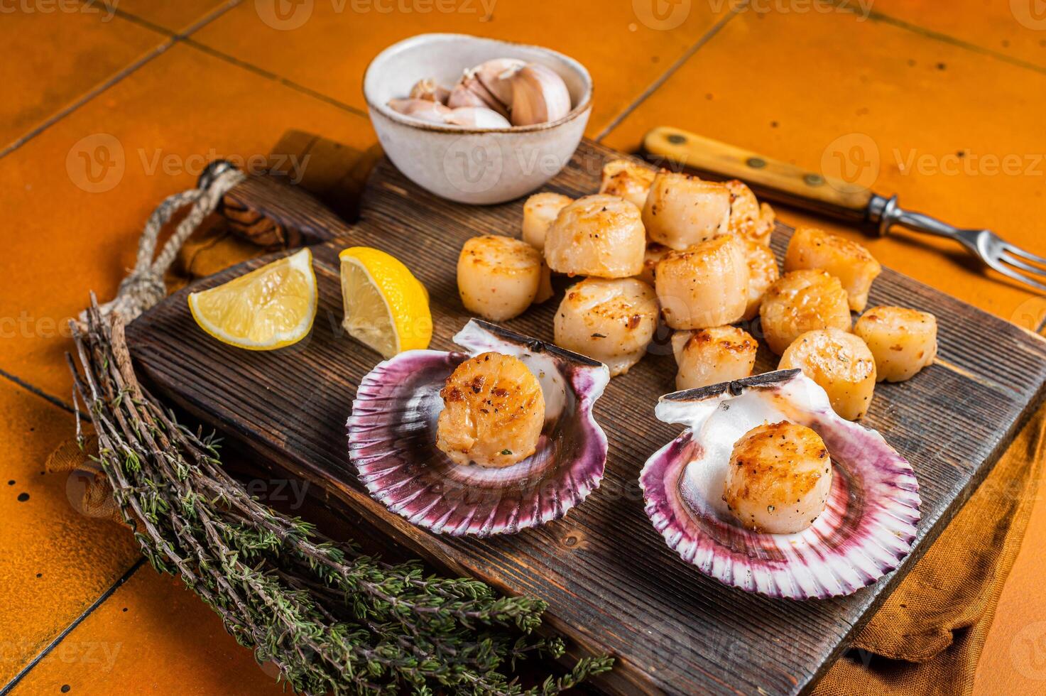 Seared Scallops fillets on a wooden board ready for eat. Orange background. Top view photo