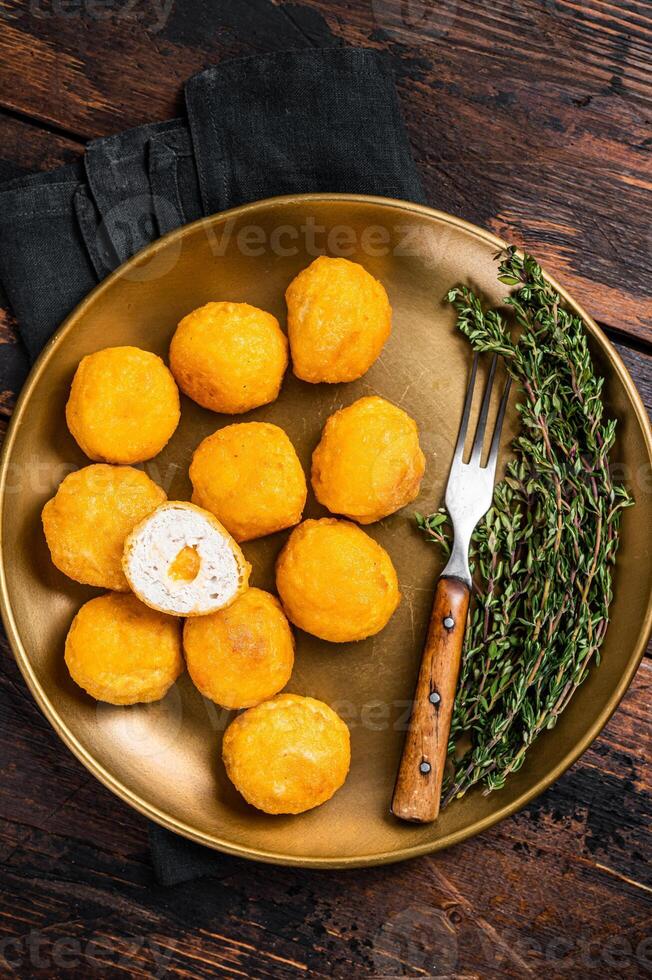 Fried crispy round chicken nuggets with Cheese. Wooden background. Top view photo