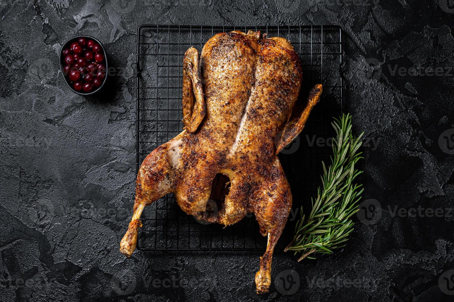 Roast whole duck, festive christmas recipe. Black background. Top view photo