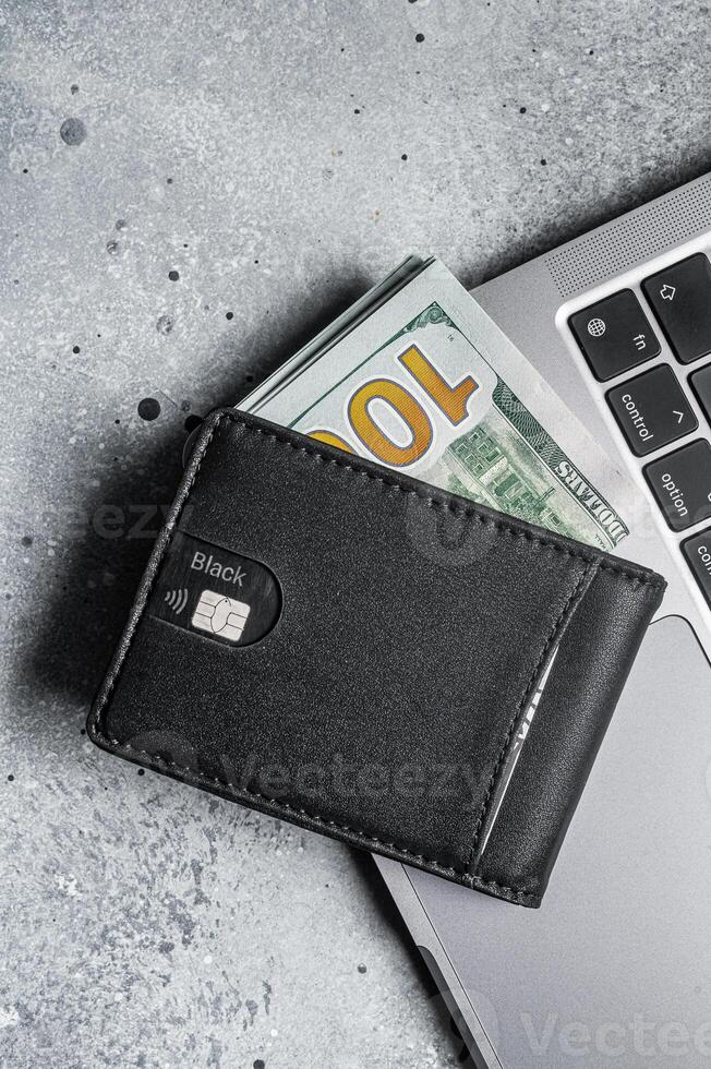 Workplace with stylish leather wallet with money, Laptop. Gray background. Top view. Copy space photo