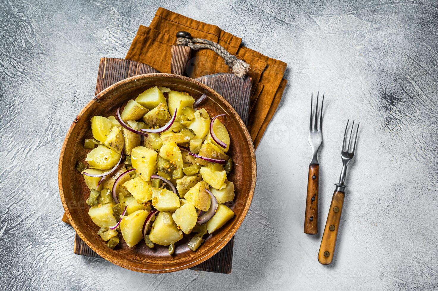 Bowl of warm potato salad with bacon, German Kartoffelsalat. White background. Top view photo