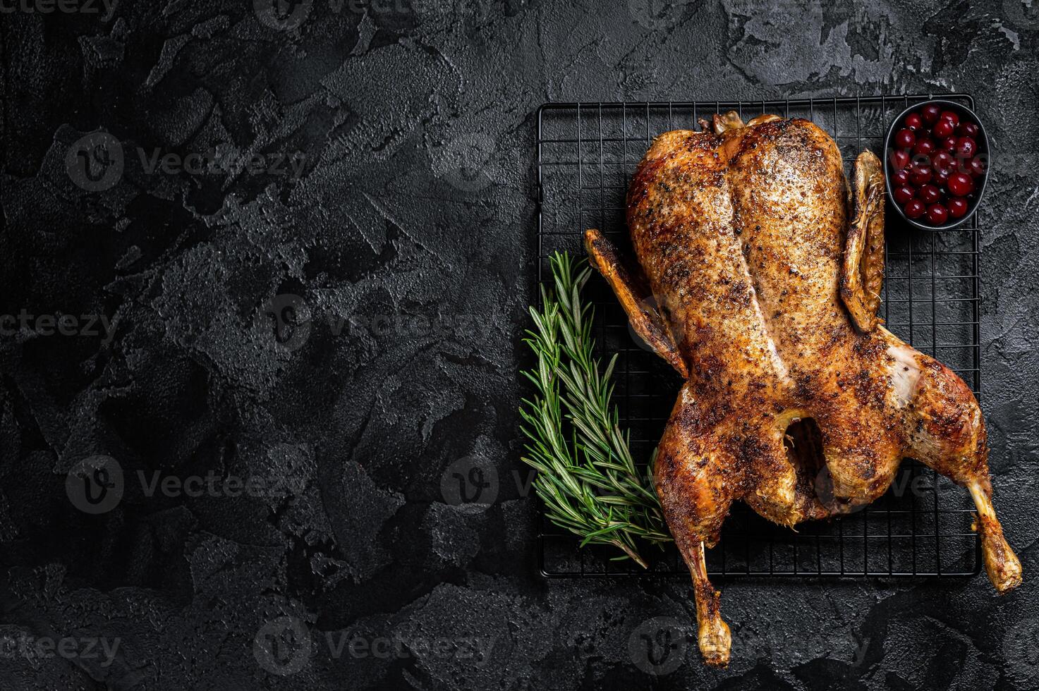 Roast whole duck, festive christmas recipe. Black background. Top view. Copy space photo