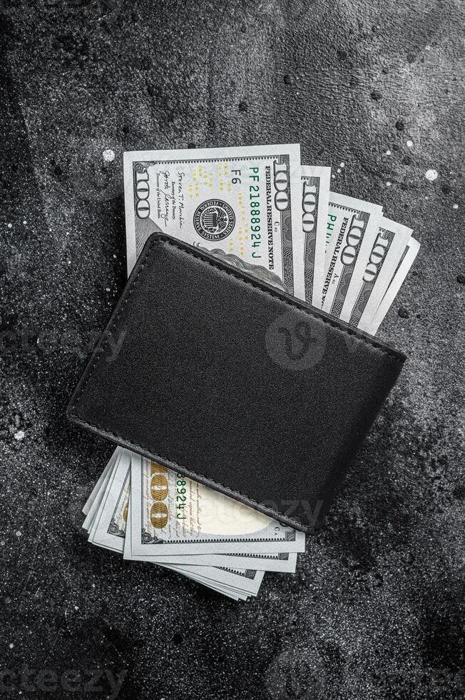 One black purse with the big pack of dollars, Cash of dollar note. Black background. Top view. Copy space photo