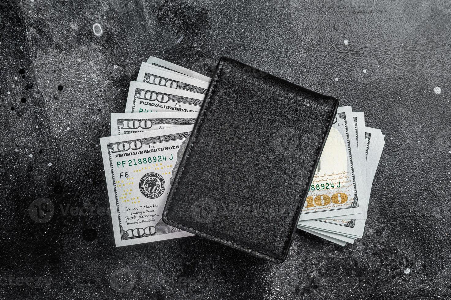 One black purse with the big pack of dollars, Cash of dollar note. Black background. Top view. Copy space photo